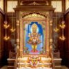 Divine figure in ornate traditional garments standing on a pink lotus pedestal, surrounded by a golden ornamental arch.